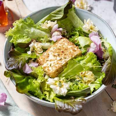 Blattsalat mit gebackenem Feta und essbaren Blüten